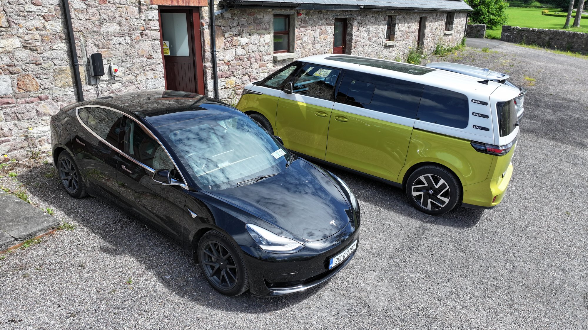 Tesla Model Y and VW ID Buzz at the stone office building